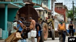 Un grupo de personas colectan agua en San Antonio, Artemisa tras inicio del desconfinamiento 