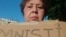 La intelectual matancera alina Bárbara López Hernández sostiene un cartel que demanda la amnistía para los presos políticos en Cuba. 