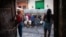 Residentes transportan recipientes mientras hacen fila para obtener agua potable de un camión cisterna, en Matanzas, Cuba.