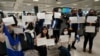 Activistas sostienen carteles con los nombres de algunos de los más de 200 presos políticos liberados de Nicaragua, mientras esperaban su llegada al Aeropuerto Internacional Dulles en Virginia, en las afueras de Washington, EEUU, el 9 de febrero de 2023. (Reuters/Kevin Lamarque).