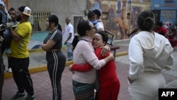 Una mujer consuela a un niño en la calle tras un terremoto en Caracas el 24 de junio de 2026.