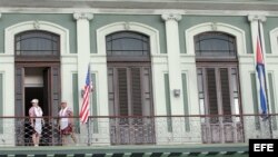 Dos empleadas acomodan una bandera estadounidense en el hotel donde llegó una comitiva de senadores de EE.UU. 