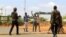Oficiales de seguridad interrogan a civiles en la carretera donde los médicos fueron secuestrados. en Mandera Kenia.