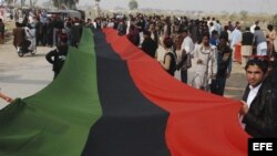 Simpatizantes del gobernante Partido Popular (PPP) portan una bandera del partido durante un acto para rendir tributo a la exprimera ministra paquistaní Benazir Bhutto con motivo de el quinto aniversario de su asesinato.