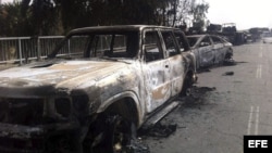 Vista de unos vehículos carbonizados después de ser atacado por unos insurgentes en Mosul, en el norte de Irak, hoy, jueves 12 de junio de 2014. 