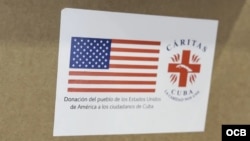 Los paquetes de ayuda humanitaria desde Estados Unidos a Cuba llevan esta etiqueta que incluye la bandera estadounidense y el logotipo de Cáritas Cuba. 